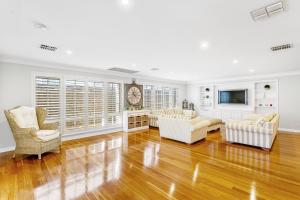 een woonkamer met witte meubels en een televisie bij 56 Picture Perfect Applecross 5br 3bth in Perth