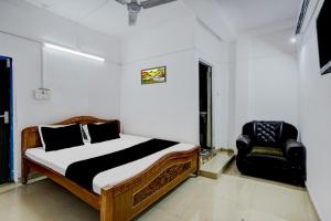 ein Schlafzimmer mit einem Bett und einem Stuhl darin in der Unterkunft OYO Flagship Hotel Shiv Residency in Ranchi