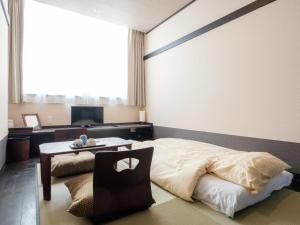 a bedroom with a bed and a table in it at The Premium Hotel In Rinku in Izumi-Sano