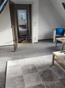 レンズブルクにあるFerienwohnung Arffの鏡、ソファ、テーブルが備わる客室です。