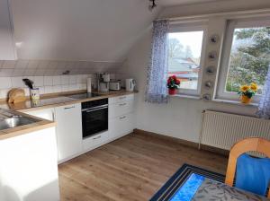 uma cozinha com armários brancos e uma janela em Ferienwohnung Arff em Rendsburg