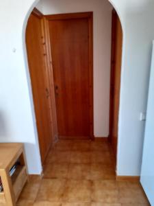 - un couloir avec une porte en bois et du parquet dans l'établissement apartment for couples 257, à Arenal d'en Castell 2 autres photos