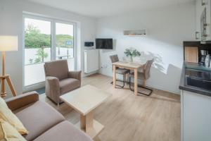 a living room with a couch and a table at Haus an den Dünen in Norderney +21 photos