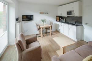a living room with a table and a kitchen at Haus an den Dünen in Norderney