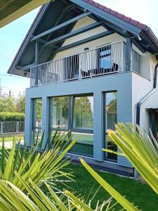 a house with a balcony and some plants at Kikapcs apartman in Alsóörs