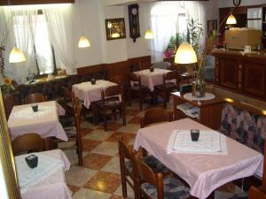 un restaurante con mesas y sillas con mantel blanco en Albergo Antica Rosa, en Levico Terme