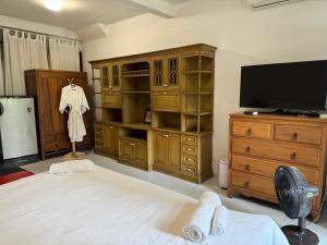 a bedroom with a bed and a tv and a dresser at Many Trees in Bangkok
