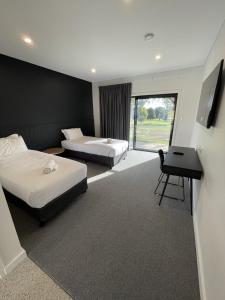 um quarto de hotel com duas camas e uma secretária em Harden Country Club Motel em Harden