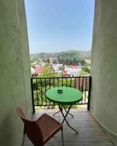 a green table and chairs on a balcony at Green Flower Hotel in Kutaisi