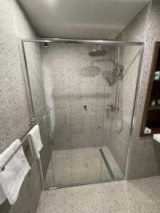 um chuveiro com uma porta de vidro na casa de banho em Harden Country Club Motel em Harden