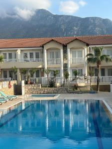 un hotel con piscina frente a un edificio en Larimar Suite Hotel, en Ölüdeniz