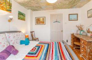 a bedroom with a bed with a colorful rug at The Cherries in York