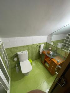 a bathroom with a white toilet and a sink at Casa Costeira in Redondela