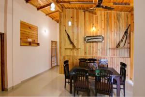 una sala da pranzo con tavolo e sedie di Goroomgo Wooden Umbrella Bhimtal - Natural landscape Mountain View a Bhimtal