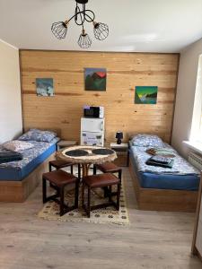 a room with two beds and a table and chairs at Krok od Biebrzy in Dolistowo Stare