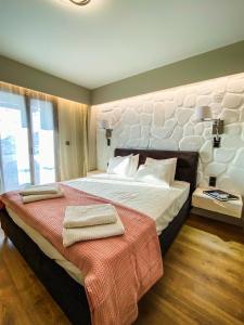 a bedroom with a large bed with towels on it at Apellou Apartments in Vathý