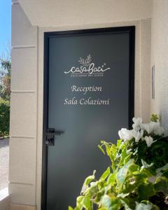 a door with a sign on it with a plant at CASA BACI - Soggiorno nel Gusto in Colà di Lazise