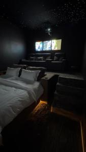a dark room with a bed and a couch at شقة فاخرة بغرفة سينما وحديقة in Qabāʼ