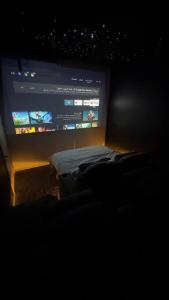 a room with a large screen in a dark room at شقة فاخرة بغرفة سينما وحديقة in Qabāʼ