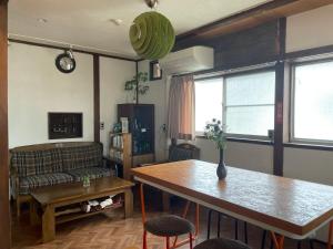 a living room with a table and a couch at 北アルプス麓のゲストハウス林屋 204 in Omachi