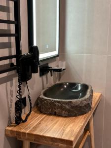 a bathroom with a black sink and a phone at SAVOIE Apartments Bukovel in Bukovel