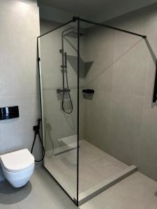 a glass shower stall in a bathroom with a toilet at SAVOIE Apartments Bukovel in Bukovel