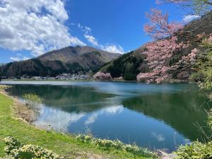 a view of a lake with mountains in the background at 北アルプス麓のゲストハウス林屋 204 in Omachi