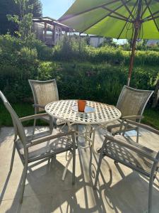 uma mesa e cadeiras com um guarda-sol num pátio em Ferienwohnung -Schwalbe em Attendorn