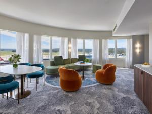 墨爾本的住宿－希爾頓墨爾本國際機場酒店，客厅设有桌椅和窗户。