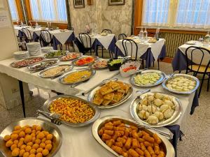 a table with many plates of food on it at Albergo Regina Mundi in Pietra Ligure