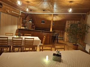ein Esszimmer mit Tischen, Stühlen und Lampen in der Unterkunft Lapegles 2 in Ludza
