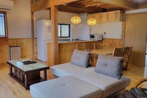 a living room with a couch and a table at SUNNY house SHIRATO ---8月末まで断水中--- in Iwaya