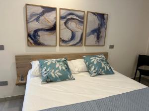 Un dormitorio con una cama con tres cuadros en la pared. en Villa Lucia, en Pompeya