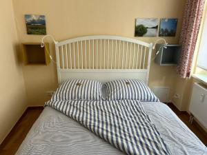 uma cama com duas almofadas e dois monitores na parede em Körner Nr 2 - ABC26 em Wismar