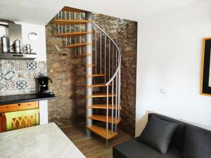 a spiral staircase in a living room next to a kitchen at Antico borgo tra i laghi in Meina