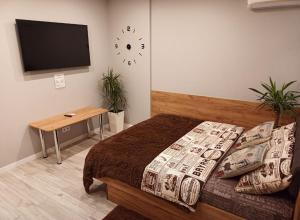 Schlafzimmer mit einem Bett und einem Flachbild-TV in der Unterkunft Amazing Lux Studio Apartment in the Comfort Town KT-07 in Kiew