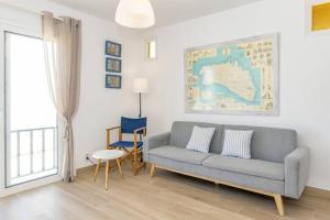 uma sala de estar com um sofá e uma cadeira em Ponent-Apartamento frente al mar, refugio costero em Es Grau