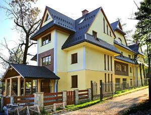 ザコパネにあるApartament Cicha Woda Zakopaneの黒屋根の大黄色い家