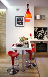 a kitchen with red bar stools and a white table at Apartament Cicha Woda Zakopane in Zakopane