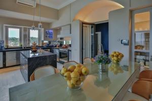 a kitchen with a glass table with a bowl of fruit on it at VataFinca villa in Sant Josep de sa Talaia