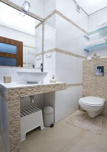 a white bathroom with a sink and a toilet at Apartament Cicha Woda Zakopane in Zakopane