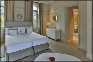 a bedroom with a large white bed and a mirror at VataFinca villa in Sant Josep de sa Talaia