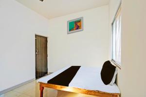 a white room with a bed with a window at SPOT ON Hotel SB Air Port Stay in Phundardih