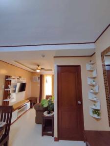 uma sala de estar com uma porta castanha e um sofá em Palawan Paradise Condotel 2B em Puerto Princesa