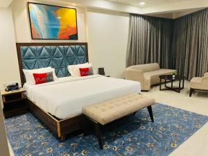 Playotel Premier Guna في Guna: غرفة فندقية بسرير كبير وكرسي