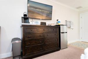 a large wooden dresser in a kitchen with a refrigerator at Be A Nomad - 1 blk to beach - Stylish studio in Jacksonville Beach