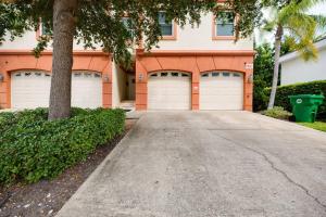 a house with four garage doors in a driveway at Be A Nomad - 1 blk to beach - Stylish studio in Jacksonville Beach