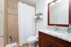 a bathroom with a sink and a toilet and a mirror at Be A Nomad - 1 blk to beach - Stylish studio in Jacksonville Beach