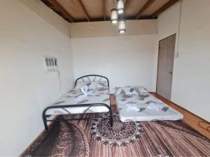 Cama en habitación con alfombra en Masamirey Hilltop Cottage Seaview with Private White Beach Access, en Sual