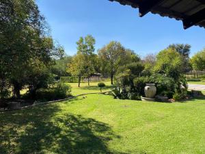 a park with a green lawn with a vase and trees at The Garden Haven in Midrand